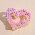 Detail of a large pink heart claw clip with colorful star sequins and durable metal spring - Pink