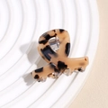 Macro detail of high-quality acetate hair claw clip with classic tortoiseshell pattern finish - Light Leopard