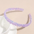 Détail de strass colorés sur un serre-tête fin posé sur une tasse en céramique blanche - Strass Bleu Violet Rose