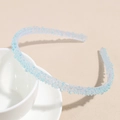 Détail d'un serre-tête bleu clair en gelée avec des strass colorés sur une tasse blanche - Bleu Perle de Rêve