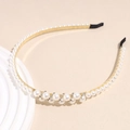 Dettaglio di un cerchietto dorato con perle bianche e strass scintillanti per capelli - Perla Avvolta in Strass