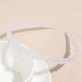 Détail d'un serre-tête blanc translucide avec perles irisées sur une tasse - Blanc Perle de Rêve