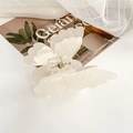 Detailed macro shot of a pearlescent double-layered butterfly hair claw clip with golden spring - Beige