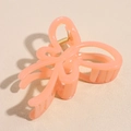 Detail view of large coral pink jelly butterfly hair claw clip with strong gold spring - Orange