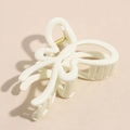 Detail of a creamy beige butterfly hair claw clip with a glossy finish and gold spring - Ivory