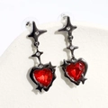 Macro shot of dark heart-shaped earrings with red crystal and sparkling star detail - Black Star Red Heart Style / One Heart