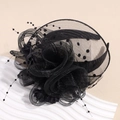 Dettaglio di un cappello fascinator nero vintage con velo a rete a pois e fiore di tulle - Nero