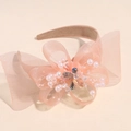 Dettaglio di cerchietto con fiocco in rete rosa, perle e cristalli su fondo beige - Rosa Arancio