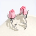 Macro detail of pink rose earring with a silver-colored thorn stem on white pedestal - Pink 3D Rose Style / Rose