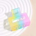 Dettaglio di un fermaglio per capelli opaco arcobaleno su un piatto decorativo bianco - Stile Rettangolare Sfumato