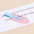 Macro view of pink translucent resin hair clip with blue peach text on display card - Streaming Blue Pink