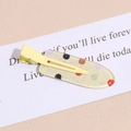 Close-up of yellow metal hair clip with colorful polka dots and shimmer glitter detail - Polka Dot Yellow