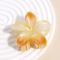 Detail of a large pearlescent gradient flower hair claw clip with golden orange tones - Orange