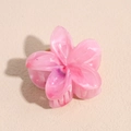 Dettaglio della pinza per capelli a fiore rosa con trama marmorizzata e molla in metallo - Rosso rosa