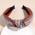 Detalle de diadema bohemia trenzada con textura geométrica en bandeja de cerámica - Estilo Jacquard Rojo Ladrillo