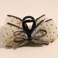Detail of beige polka dot mesh hair claw clip with sparkly rhinestone bow centerpiece - Champagne