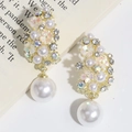 Detalle de pendientes florales dorados con pequeñas perlas blancas y grandes perlas de gota - Flor de Perla Blanca Diamante