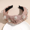Dettaglio di fiori di perle cuciti a mano e strass su una fascia annodata rosa cipria - Marrone