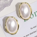 Primer plano de elegantes pendientes de perla ovalada con marco dorado martillado - Perla Grande Ovalada Irregular
