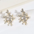 Detalle de pendientes de copo de nieve con brillantes pedrería y perlas sobre dorado - Coral de Perla Y Diamante