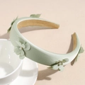 Dettaglio del cerchietto in tessuto verde menta con texture seta e decorazioni floreali - Verde