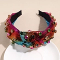 Detalle de diadema anudada degradado arcoíris con strass de colores en plato blanco - Degradado Naranja Rosa Rojo Verde