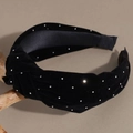 Detail eines geknoteten Samt-Stirnbands mit Strasssteinen auf grauem Grund - Schwarz