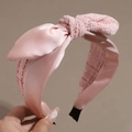 Detalle de la diadema de tweed rosa con lazo de satén mostrando la textura del tejido - Rosa