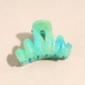 Close-up of green and blue marble texture on a plastic hair claw clip with matte finish - 4.5cm Teal Wavy Claw