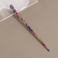Primer plano detallado de un pasador de pelo de acetato multicolor con un diseño retorcido - Rojo Rosa Azul Multicolor