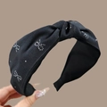 Detail of black fabric headband with silver glitter butterfly patterns and knotted design - Knotted Style / Black Knot