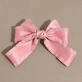 Detailed view of a pink satin bow hair clip with ruffled edges and silk texture - Pink