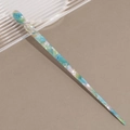 Detalle de la textura jaspeada en un pasador de pelo de acetato azul con diseño en espiral - Verde azulado