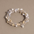 Close-up of woven hair tie with soft pom-poms and durable cylindrical resin fastener - Tan