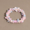 Detailed macro view of colorful pom-poms on a high elasticity spiral hair tie accessory - Light Pink