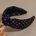 Detail van de geknoopte haarband met kleurrijke pailletten op een zwarte stof - Zwart