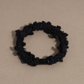 Macro shot of black textured bobble hair tie with sleek rectangular closure clip - Black