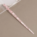 Detailed macro shot of a pink marble acetate hair stick with a twisted spiral top design - Transparent Pink White