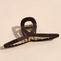 Dettaglio di un mollettone per capelli lucido marrone scuro da 12cm con denti dorati - caffè