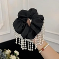 Detailansicht eines schwarzen Seiden-Scrunchies mit eleganten langen Perlenquasten - Schwarz