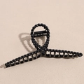 Detail view of a matte black twisted hair claw clip with strong metal spring - Black X-Twist Shape