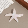 Close-up of starfish acetate hair clip showing pearlescent texture and metal spring clip - Iridescent Beige