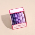 Dettaglio di 6 elastici per capelli a spirale viola in una scatola regalo rosa - Serie Viola