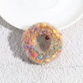 Macro detail of plush brown knit scrunchie featuring colorful polka dot pom-pom accents - Brown