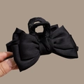 Close-up of a large black satin bow claw clip held in hand to show size and texture - Black