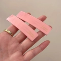 Primer plano de pinzas de acrílico rosa con letras doradas Barrette la France - Rosa
