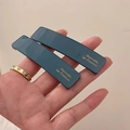 Primer plano de horquillas de acrílico azul marino con letras doradas y acabado brillo - Azul