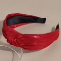 Detail des roten Knotenstirnbands mit Metallic-Strick auf Acrylständer für Damen - Rot