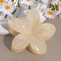 Nahaufnahme der cremefarbenen Blumen-Haarklammer mit Glitzer-Finish auf Deko-Fläche - Lilie Beige