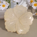 Makroansicht der cremefarbenen Haarklammer mit glitzernden Blütenblättern - Rollblume Beige